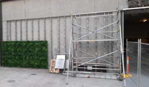 A failed green wall being replaced with plastic plants