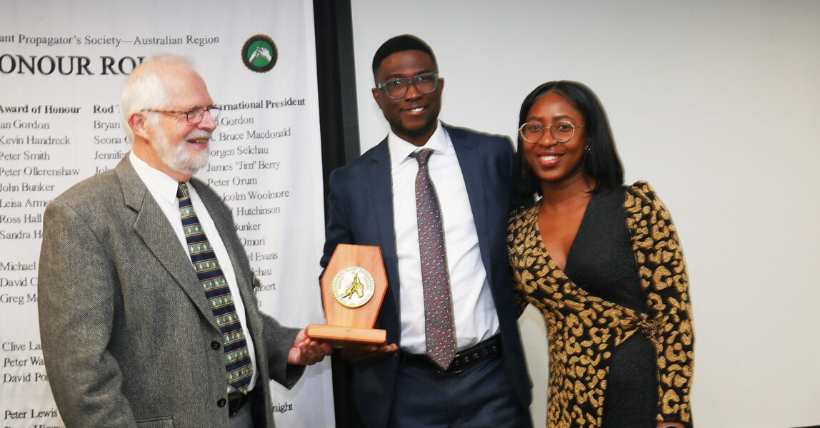 Brice Higgs presenting the Rod Tallis Award to Elliot Akintola, pictured with his wife Joana
