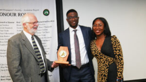 Brice Higgs presenting the Rod Tallis Award to Elliot Akintola, pictured with his wife Joana