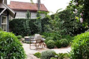 The front garden has a cottage-style feel, including a water feature and plantings of annuals and camellias