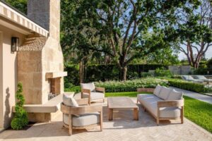 A sandstone outdoor fireplace and informal seating area were added to this garden as part of the new landscaping design, which included Buxus microphylla topiary spirals