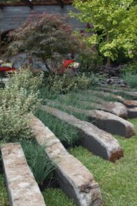 Stone dividers, resilient grasses, Australian plants and perennial shrubs with small trees (Image: John Fitzsimmons)