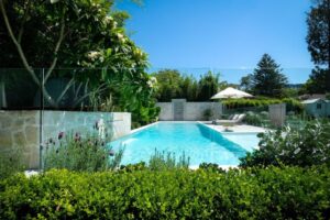 The stunning pool renovation surrounded by hedges, the purple hues of lavender and the successfully transplanted frangipani tree (image supplied by The Landscape Association)