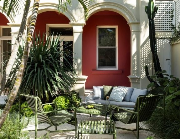 A rich backdrop accentuates the elegant curves of the architecture, while lush textural plantings soften the heavy columns and encourage a sense of discovery